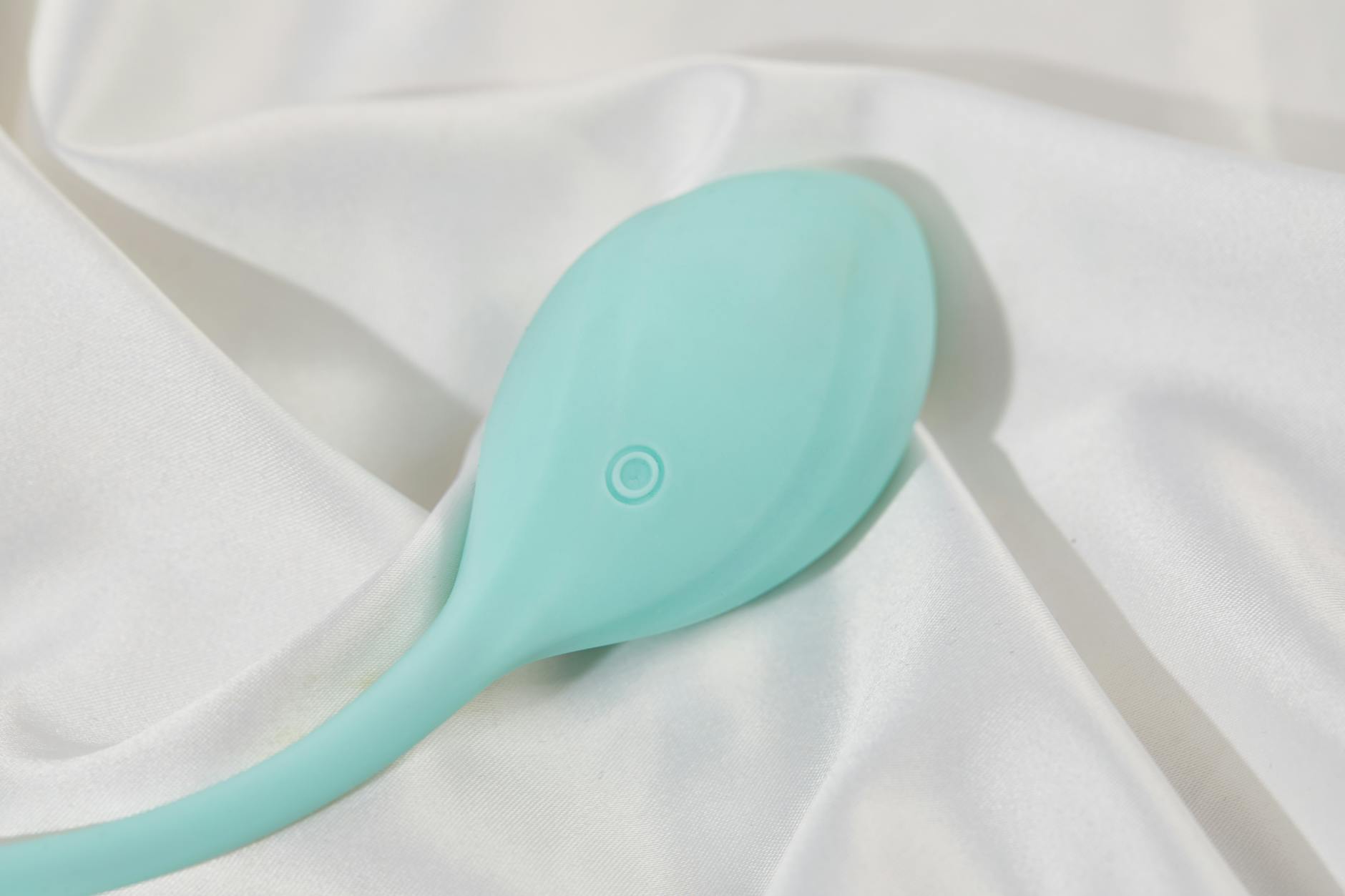 Stilvoller Lemon Vibrator auf weißem Seidengewebe, der moderne Intimität und Technologie zeigt