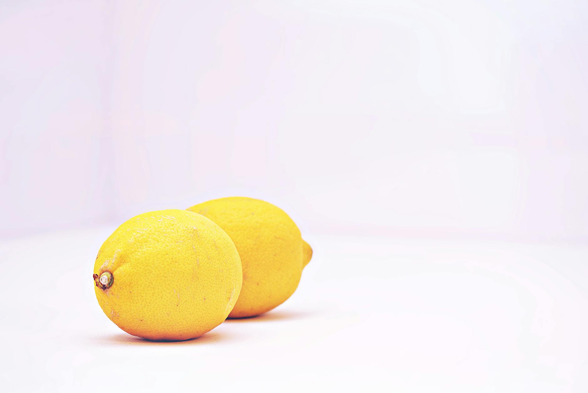 Zwei lebendige Zitronen auf minimalistische Weise präsentiert, symbolisieren Frische und Einfachheit