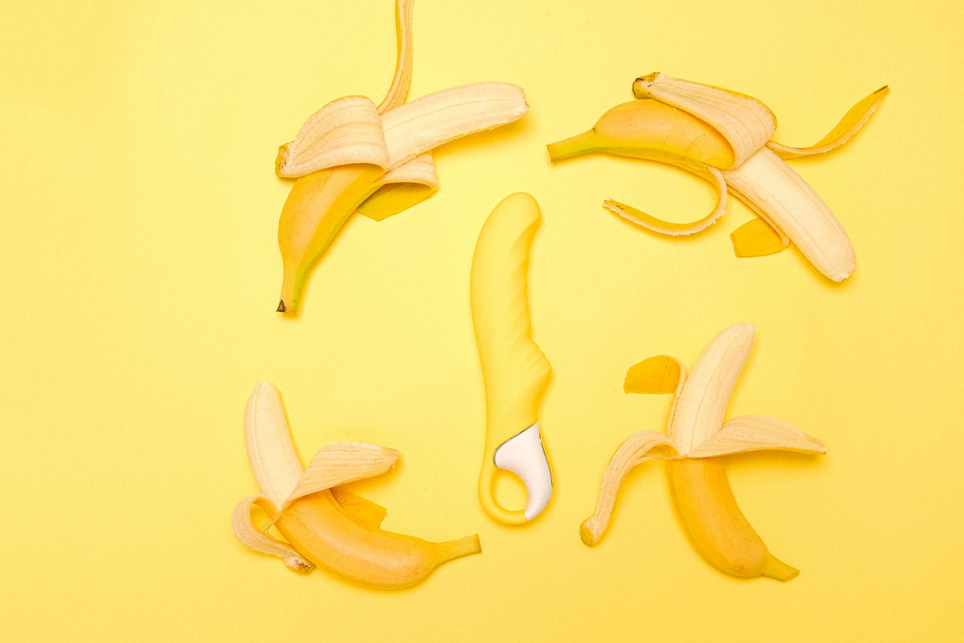 Gelber Lemon Vibrator umgeben von Zitronenscheiben auf gelbem Hintergrund