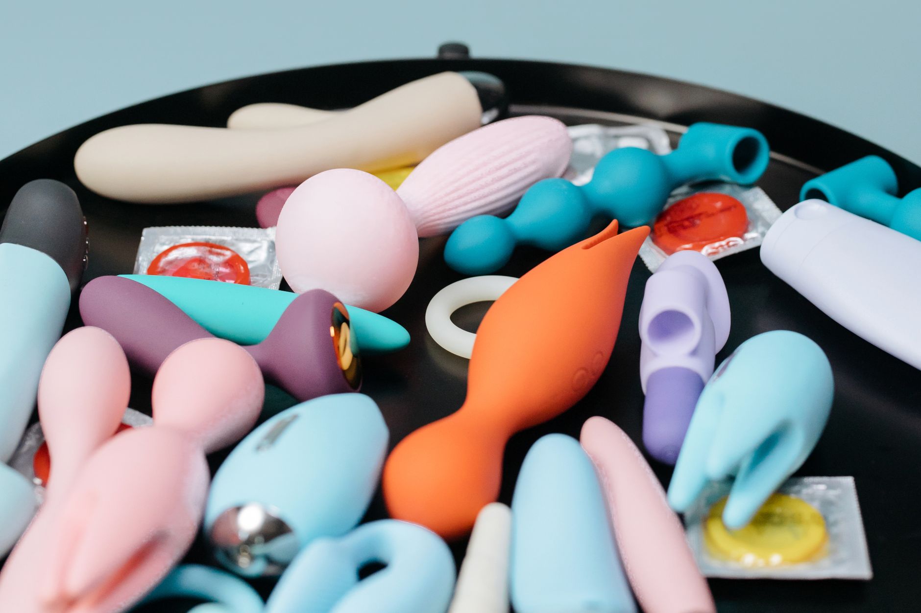 Ein Paar, das einen blauen Vibrator hält und sich nah beieinander anschmiegt