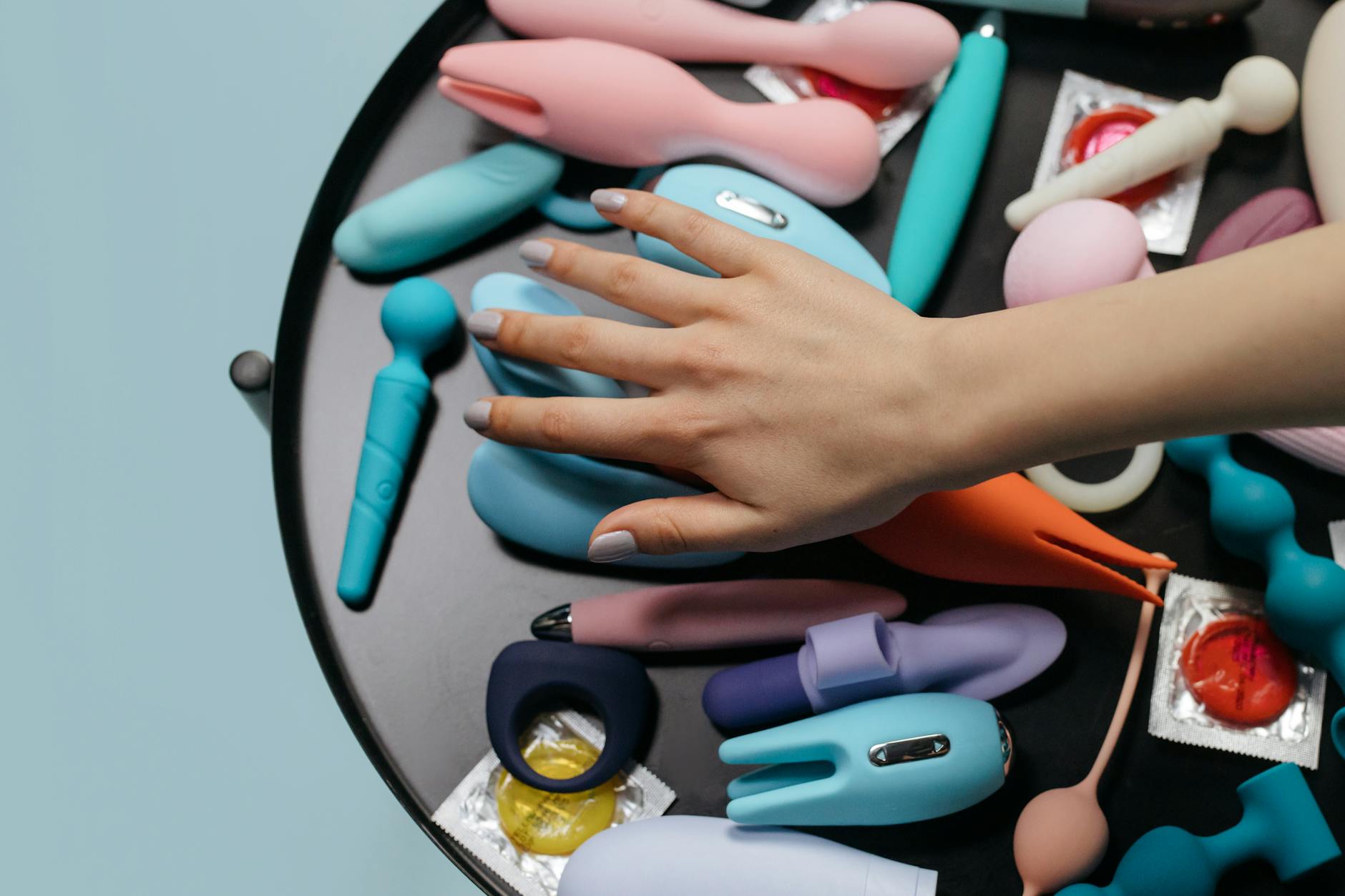 Eine Hand hält einen eleganten Lemon Vibrator gegen einen lila Hintergrund