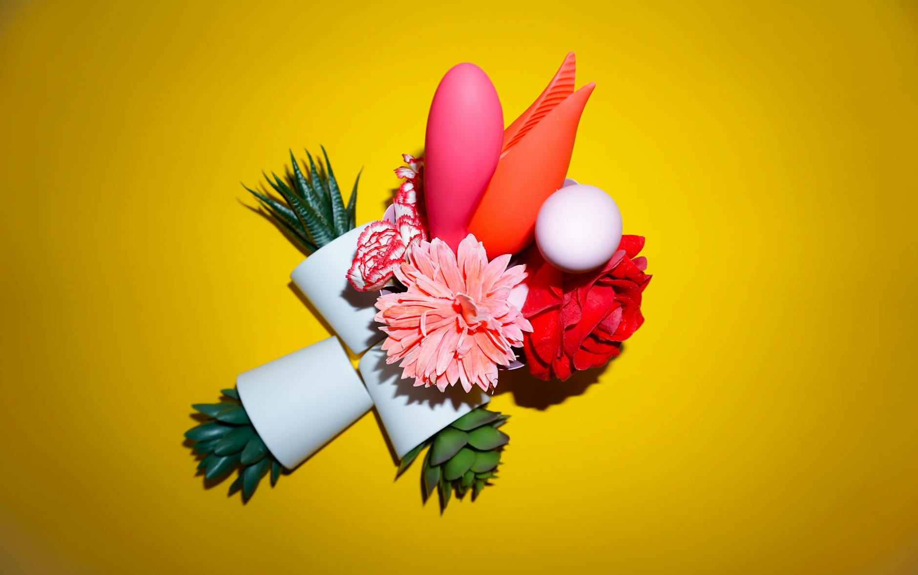 Eine Hand hält einen modernen Lemon Vibrator gegen einen minimalistischen violetten Hintergrund